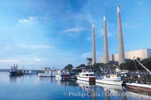 The Morro Bay Power Plant, with its distinctive three stacks, rises above fishing boats in Morro Bay harbor.  Morro Bay