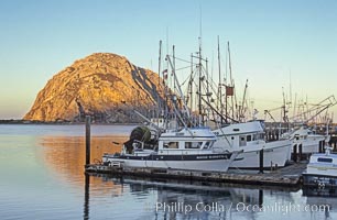 Fishing boats line the docks at sunrise, Morro Rock in the background, Morro Bay, California