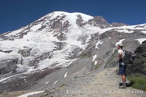 A hiker views the Nisqually Glacier and Mount Rainier from the Skyline Trail, Mount Rainier National Park, Washington