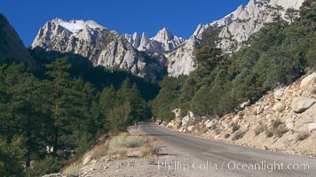 Mount Whitney rises above the Whitney Portal Road which leads to the trailhead from which Mt. Whitney is usually approached by climbers.  Mt. Whitney is the highest point in the contiguous United States with an elevation of 14,505 feet (4,421 m).  It lies along the crest of the Sierra Nevada mountain range.  Composed of the Sierra Nevada batholith granite formation, its eastern side (seen here) is quite steep.  It is climbed by hundreds of hikers each year