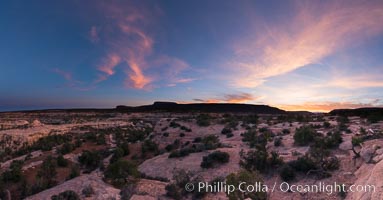 Panorama of Natural Bridges National Monument at sunset. Owachomo Bridge is visible at far left, while Natural Bridges National Monument lies under a beautiful sunset