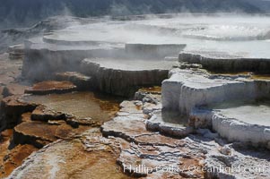 Steam rises from the travertine terraces of New Blue Spring, part of the Mammoth Hot Springs complex, Yellowstone National Park, Wyoming