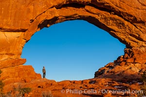 Hiker in North Window, sunset, western face.  North Window is a natural sandstone arch 90 feet wide and 48 feet high, Arches National Park, Utah