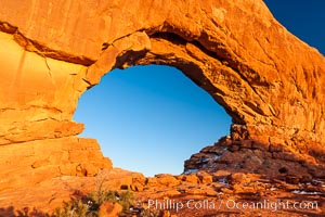 North Window glows red at sunset.  North Window is a natural sandstone arch 90 feet wide and 48 feet high, Arches National Park, Utah