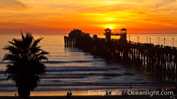 Oceanside Pier at sunset, clouds and palm trees with a brilliant sky at dusk