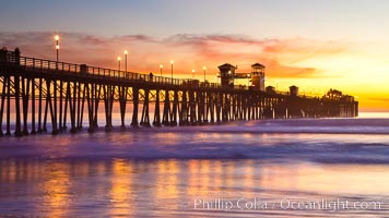 Oceanside Pier at sunset, clouds with a brilliant sky at dusk, the lights on the pier are lit