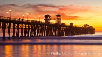 Oceanside Pier at sunset, clouds with a brilliant sky at dusk, the lights on the pier are lit