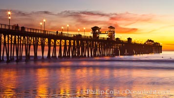 Oceanside Pier at sunset, clouds with a brilliant sky at dusk, the lights on the pier are lit