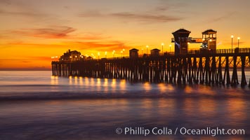 Oceanside Pier at sunset, clouds with a brilliant sky at dusk, the lights on the pier are lit