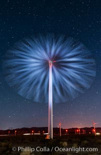 Stars rise above the Ocotillo Wind Turbine power generation facility, with a flashlight illuminating the turning turbine blades