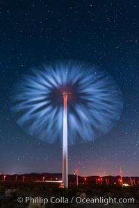 Stars rise above the Ocotillo Wind Turbine power generation facility, with a flashlight illuminating the turning turbine blades