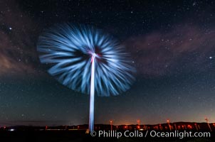 Stars rise above the Ocotillo Wind Turbine power generation facility, with a flashlight illuminating the turning turbine blades