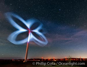 Stars rise above the Ocotillo Wind Turbine power generation facility, with a flashlight illuminating the turning turbine blades