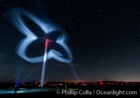 Stars rise above the Ocotillo Wind Turbine power generation facility, with a flashlight illuminating the turning turbine blades