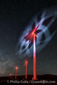 Ocotillo Wind Energy Turbines, at night with stars and the Milky Way in the sky above, the moving turbine blades illuminated by a small flashlight