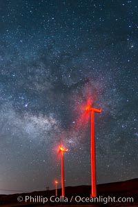 Ocotillo Wind Energy Turbines, at night with stars and the Milky Way in the sky above, the moving turbine blades illuminated by a small flashlight