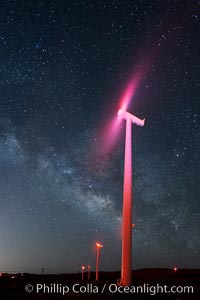 Ocotillo Wind Energy Turbines, at night with stars and the Milky Way in the sky above, the moving turbine blades illuminated by a small flashlight