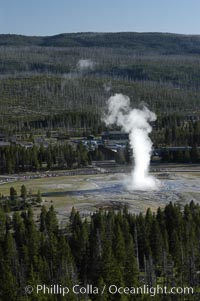 Old Faithful geyser at peak eruption, crowd viewing and Old Faithful Lodge, viewed from Lookout Point, Upper Geyser Basin, Yellowstone National Park, Wyoming