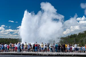 A crowd gathers to watch the worlds most famous geyser, Old Faithful, in Yellowstone National Park, Upper Geyser Basin