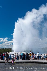 A crowd gathers to watch the worlds most famous geyser, Old Faithful, in Yellowstone National Park, Upper Geyser Basin