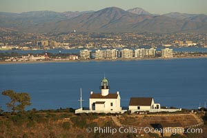 Old Point Loma Lighthouse, sitting high atop the end of Point Loma peninsula, seen here with San Diego Bay and downtown San Diego in the distance.  The old Point Loma lighthouse operated from 1855 to 1891 above the entrance to San Diego Bay. It is now a maintained by the National Park Service and is part of Cabrillo National Monument