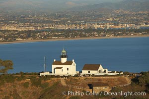 Old Point Loma Lighthouse, sitting high atop the end of Point Loma peninsula, seen here with San Diego Bay and downtown San Diego in the distance.  The old Point Loma lighthouse operated from 1855 to 1891 above the entrance to San Diego Bay. It is now a maintained by the National Park Service and is part of Cabrillo National Monument