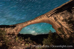 Owachomo Bridge and Milky Way.  Owachomo Bridge, a natural stone bridge standing 106' high and spanning 130' wide,stretches across a canyon with the Milky Way crossing the night sky, Natural Bridges National Monument, Utah