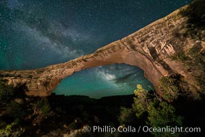 Owachomo Bridge and Milky Way.  Owachomo Bridge, a natural stone bridge standing 106' high and spanning 130' wide,stretches across a canyon with the Milky Way crossing the night sky, Natural Bridges National Monument, Utah