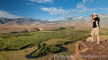 Photographer over Owens River valley, Sierra Nevada mountain range in distance, viewed from Volcanic Tablelands near Bishop, California