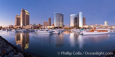 Panoramic photo of San Diego embarcadero, showing the San Diego Marriott Hotel and Marina (center), Roy's Restaurant (center) and Manchester Grand Hyatt Hotel (left) viewed from the San Diego Embarcadero Marine Park.