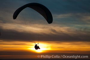 Paraglider soaring at Torrey Pines Gliderport, sunset, flying over the Pacific Ocean.