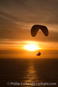 Paraglider soaring at Torrey Pines Gliderport, sunset, flying over the Pacific Ocean.