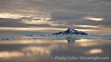 Paulet Island, near the Antarctic Peninsula, is a cinder cone flanks by lava flows on which thousands of Adelie Penguins nest