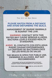 A sign warns visitors to stay away from the harbor seals at Childrens Pool in La Jolla, California while videotaping those who approach the seals.  The La Jolla colony of harbor seals, which has formed a breeding colony at a small but popular beach near San Diego, is at the center of considerable controversy.  While harbor seals are protected from harassment by the Marine Mammal Protection Act and other legislation, local interests would like to see the seals leave so that people can resume using the beach, Phoca vitulina richardsi