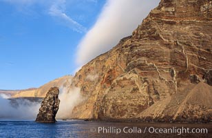 Pilot Rock (Roca Pilote), a undersea spire which extends 100 out of the water, stands below the immense seacliffs and morning clouds at the north end of Guadalupe Island (Isla Guadalupe), far offshore of the Baja California peninsula.