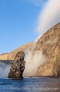 Pilot Rock (Roca Pilote), a undersea spire which extends 100 out of the water, stands below the immense seacliffs and morning clouds at the north end of Guadalupe Island (Isla Guadalupe), far offshore of the Baja California peninsula