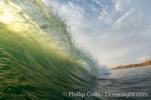 A backlit green wave breaking, sunset on Ponto Cliffs, Carlsbad.