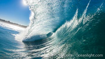 Heaving tube, wave breaks across the morning sun, Carlsbad, California.