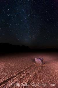 Racetrack sailing stone and Milky Way, at night. A sliding rock of the Racetrack Playa. The sliding rocks, or sailing stones, move across the mud flats of the Racetrack Playa, leaving trails behind in the mud. The explanation for their movement is not known with certainty, but many believe wind pushes the rocks over wet and perhaps icy mud in winter, Death Valley National Park, California