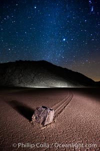 Racetrack sailing stone and Milky Way, at night. A sliding rock of the Racetrack Playa. The sliding rocks, or sailing stones, move across the mud flats of the Racetrack Playa, leaving trails behind in the mud. The explanation for their movement is not known with certainty, but many believe wind pushes the rocks over wet and perhaps icy mud in winter