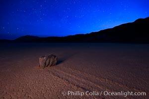 Racetrack sailing stone and stars at night. A sliding rock of the Racetrack Playa. The sliding rocks, or sailing stones, move across the mud flats of the Racetrack Playa, leaving trails behind in the mud. The explanation for their movement is not known with certainty, but many believe wind pushes the rocks over wet and perhaps icy mud in winter, Death Valley National Park, California