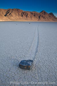Sailing stone on the Death Valley Racetrack playa.  The sliding rocks, or sailing stones, move across the mud flats of the Racetrack Playa, leaving trails behind in the mud.  The explanation for their movement is not known with certainty, but many believe wind pushes the rocks over wet and perhaps icy mud in winter, Death Valley National Park, California