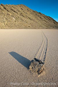 Sailing stone on the Death Valley Racetrack playa.  The sliding rocks, or sailing stones, move across the mud flats of the Racetrack Playa, leaving trails behind in the mud.  The explanation for their movement is not known with certainty, but many believe wind pushes the rocks over wet and perhaps icy mud in winter, Death Valley National Park, California