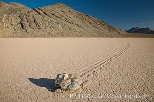 Sailing stone on the Death Valley Racetrack playa.  The sliding rocks, or sailing stones, move across the mud flats of the Racetrack Playa, leaving trails behind in the mud.  The explanation for their movement is not known with certainty, but many believe wind pushes the rocks over wet and perhaps icy mud in winter, Death Valley National Park, California