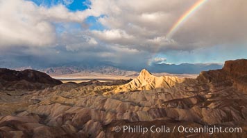 Rainbow and clearing storm clouds, sunrise light on Manly Beacon, Zabriskie Point, Death Valley National Park, California.