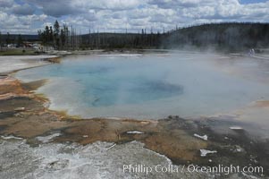 Rainbow Pool, a broad (50 foot diam) heated pool in Black Sand Basin, will rarely erupt. Usually it is calm and mildly overflowing, allowing colorful thermophilic cyanobacteria and algae to grow around its edges, Yellowstone National Park, Wyoming