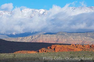 Red sandstone hills, clouds and snow covered mountains, Hurricane, Utah