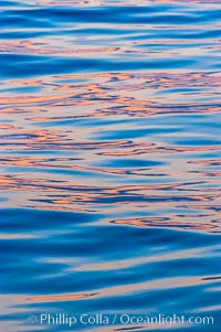 Sunset light is reflected on the ocean's placid waters