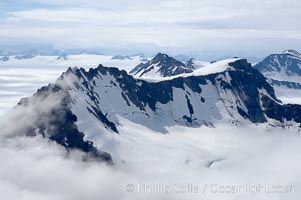 The Kenai Mountains rise above thick ice sheets and the Harding Icefield which is one of the largest icefields in Alaska and gives rise to over 30 glaciers, Kenai Fjords National Park