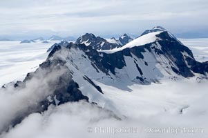 The Kenai Mountains rise above thick ice sheets and the Harding Icefield which is one of the largest icefields in Alaska and gives rise to over 30 glaciers, Kenai Fjords National Park